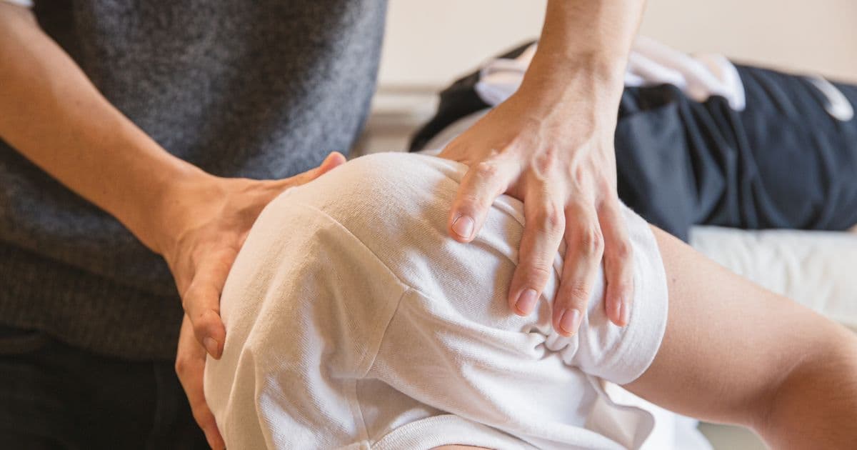 Physiotherapeut behandelt einen Patienten an der Schulter, symbolisch für den Praxisalltag ohne Zeit fürs Telefon