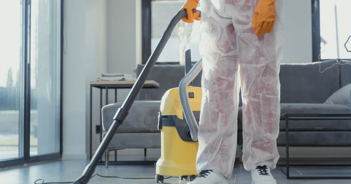 Professionelle Reinigungskraft mit Sauger bei der Endreinigung einer hellen Wohnung