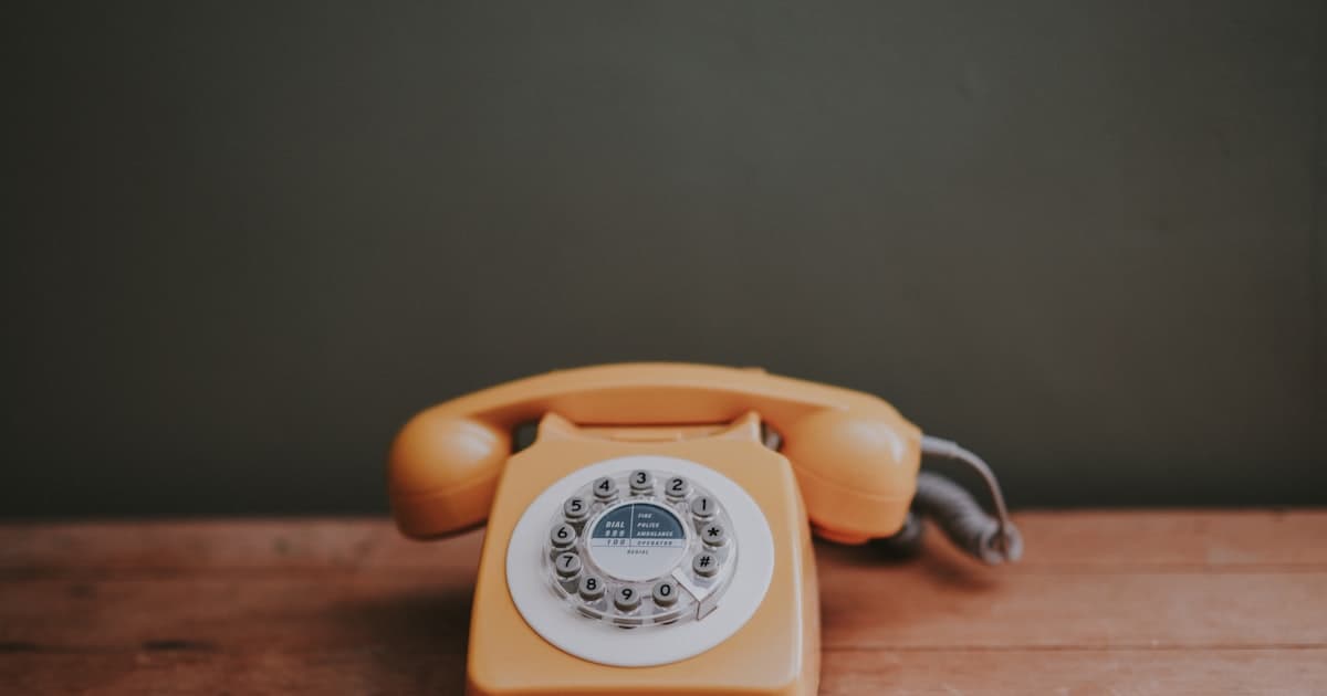 Schreibtisch mit Telefon, Notizblock und Unterlagen in einem Schweizer Sekretariat