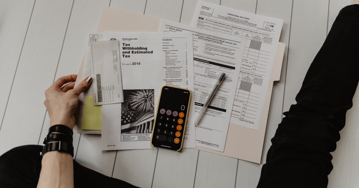 Taschenrechner und Unterlagen auf einem Schreibtisch bei der Kalkulation der Telefonservice-Kosten