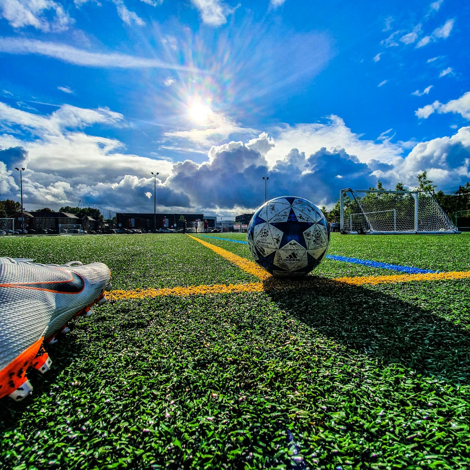Fussball auf dem Rasen eines Schweizer Vereinsplatzes unter blauem Himmel